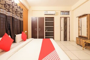 A hotel room with a bed, a wardrobe, a mirror, and an air conditioning unit. - Hotel O Rajwada-2 (Bhopal)