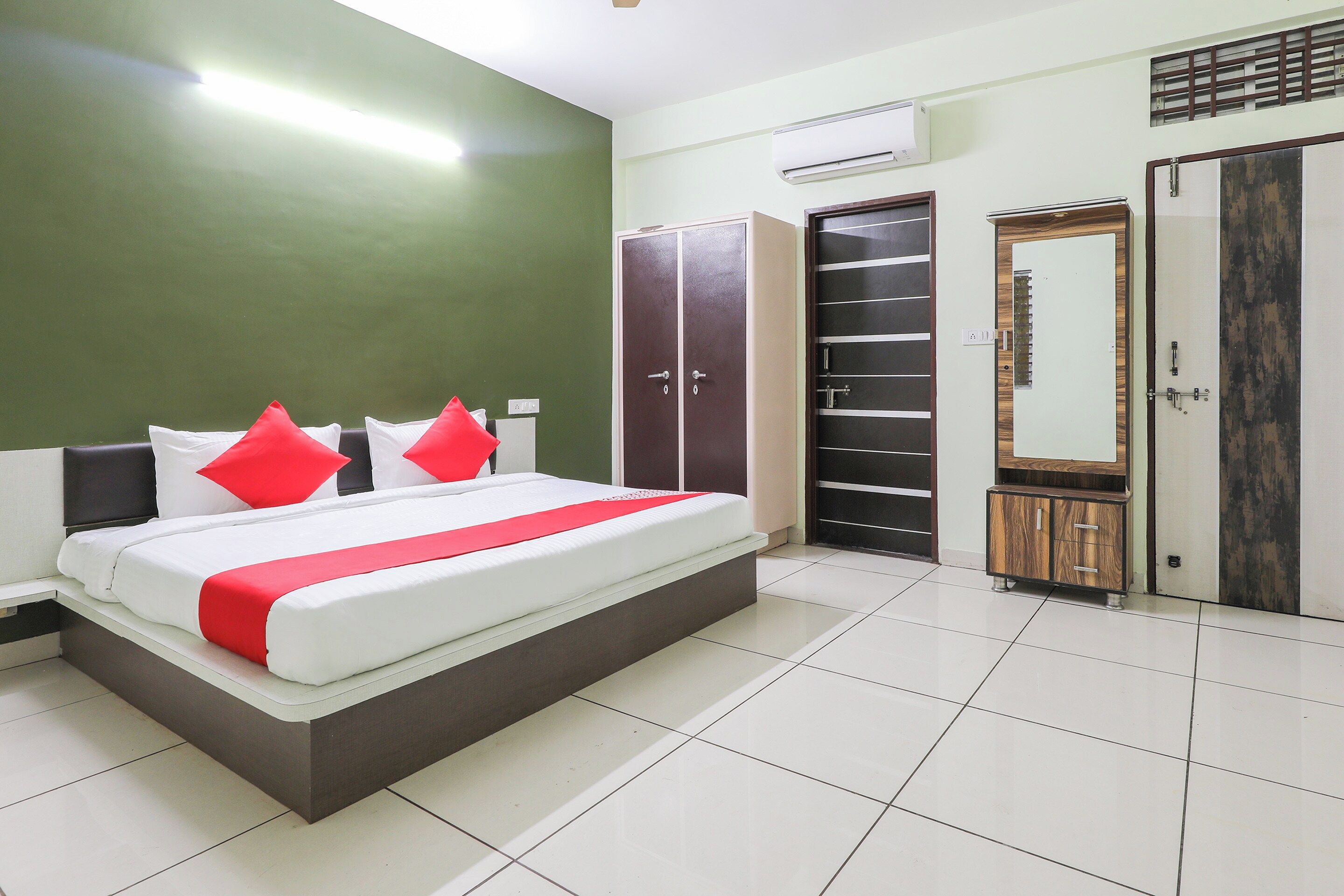 Ein Schlafzimmer mit Bett, Kleiderschrank und Spiegel.