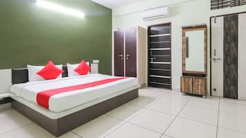 Ein Schlafzimmer mit Bett, Kleiderschrank und Spiegel.