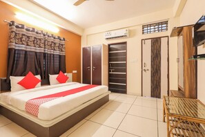 A hotel room with a bed, a wardrobe, a mirror, and an air conditioning unit. - Hotel O Rajwada-2 (Bhopal)