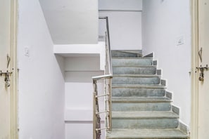 Un escalier avec des rampes en métal et un mur blanc.