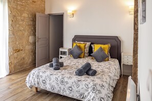 A bedroom with a bed, pillows, a nightstand, and a door. - New Listing (Milhac-de-Nontron)
