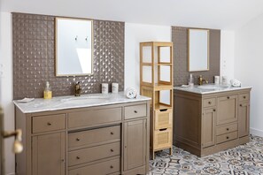 A bathroom with two sinks, a mirror, and a wooden shelf. - New Listing (Milhac-de-Nontron)