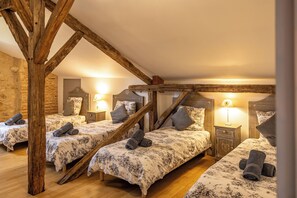 A room with three beds, wooden beams, and a warm ambiance. - New Listing (Milhac-de-Nontron)