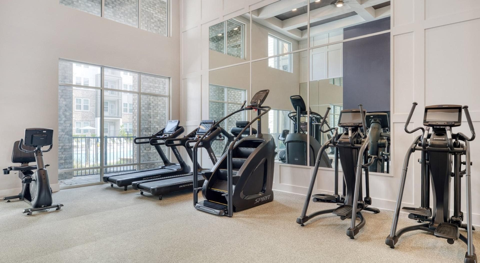A gym with treadmills, an elliptical, and a stationary bike.