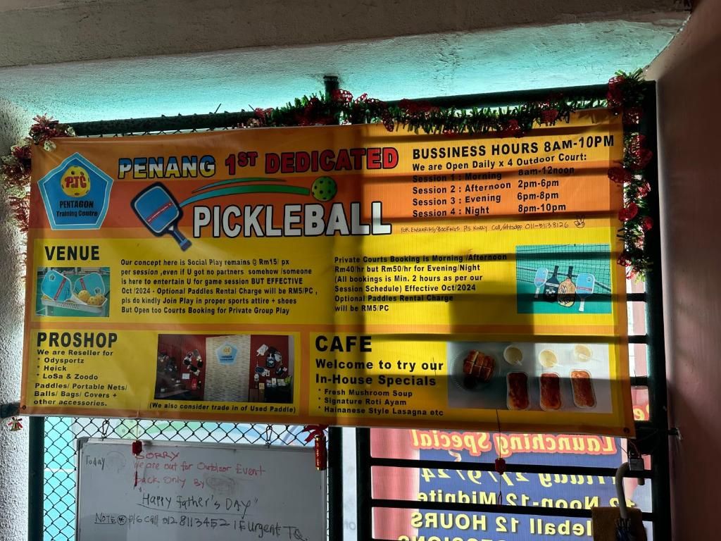A pickleball court sign with business hours, venue details, and a pro shop listing sports equipment.