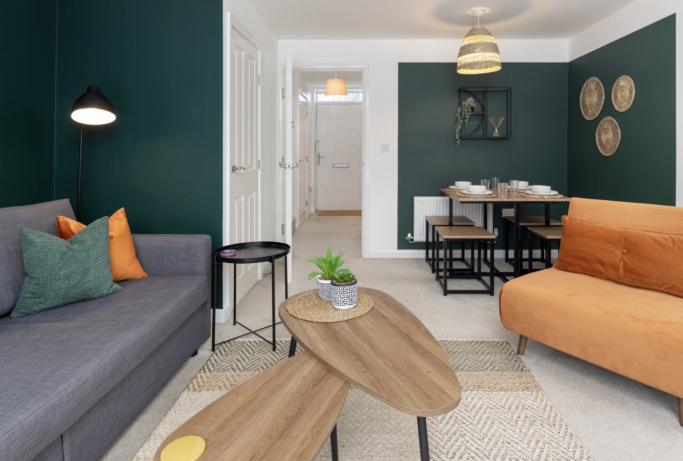 Ein Wohnzimmer mit einer Couch, einem Couchtisch und einem Essbereich mit Tisch und Stühlen.