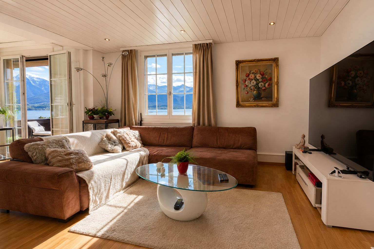 A living room with a sofa, a glass coffee table, and a painting on the wall.