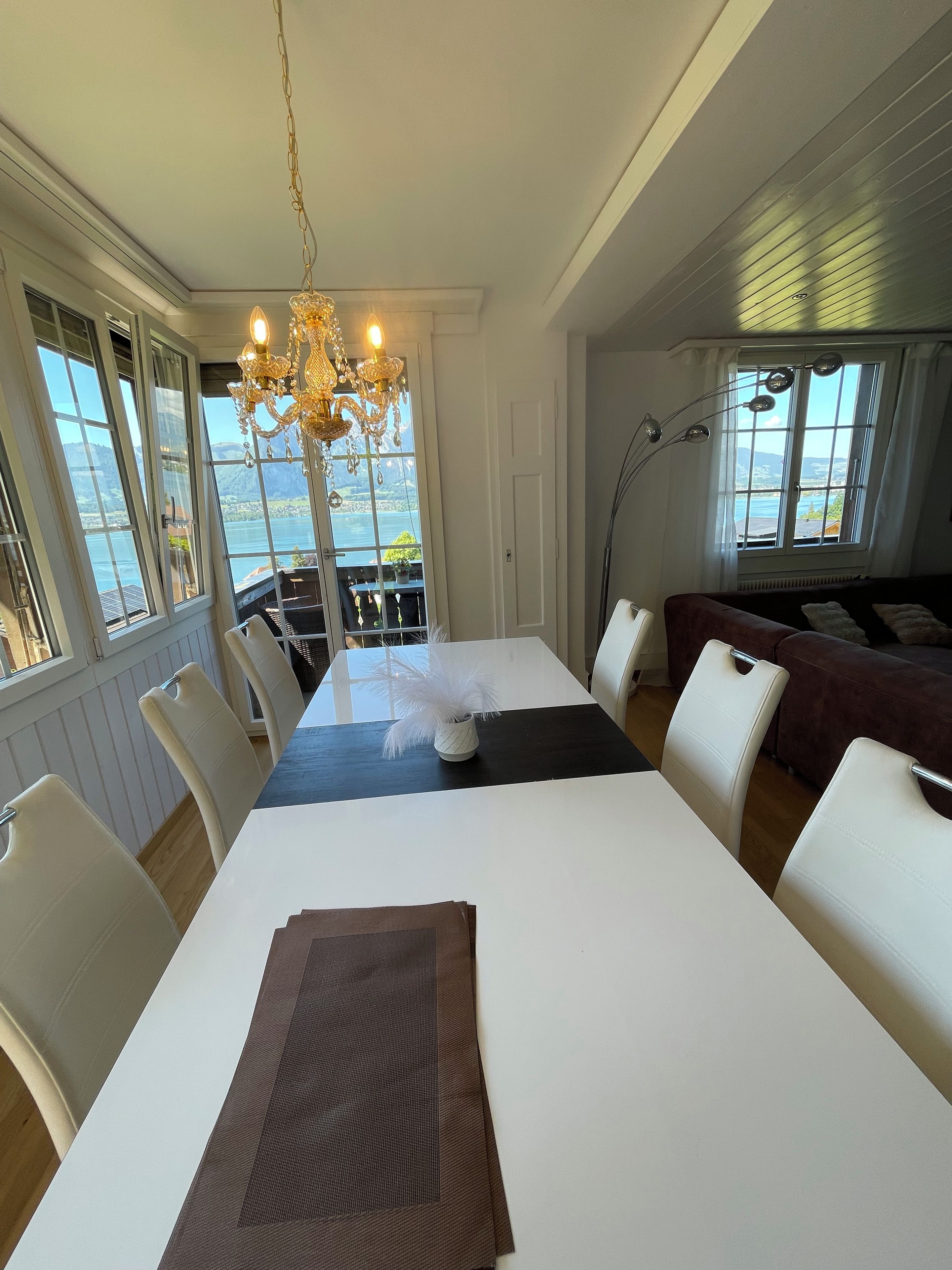A dining area with a table, chairs, and a view of the water.