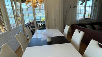 A dining area with a table, chairs, and a view of the water.