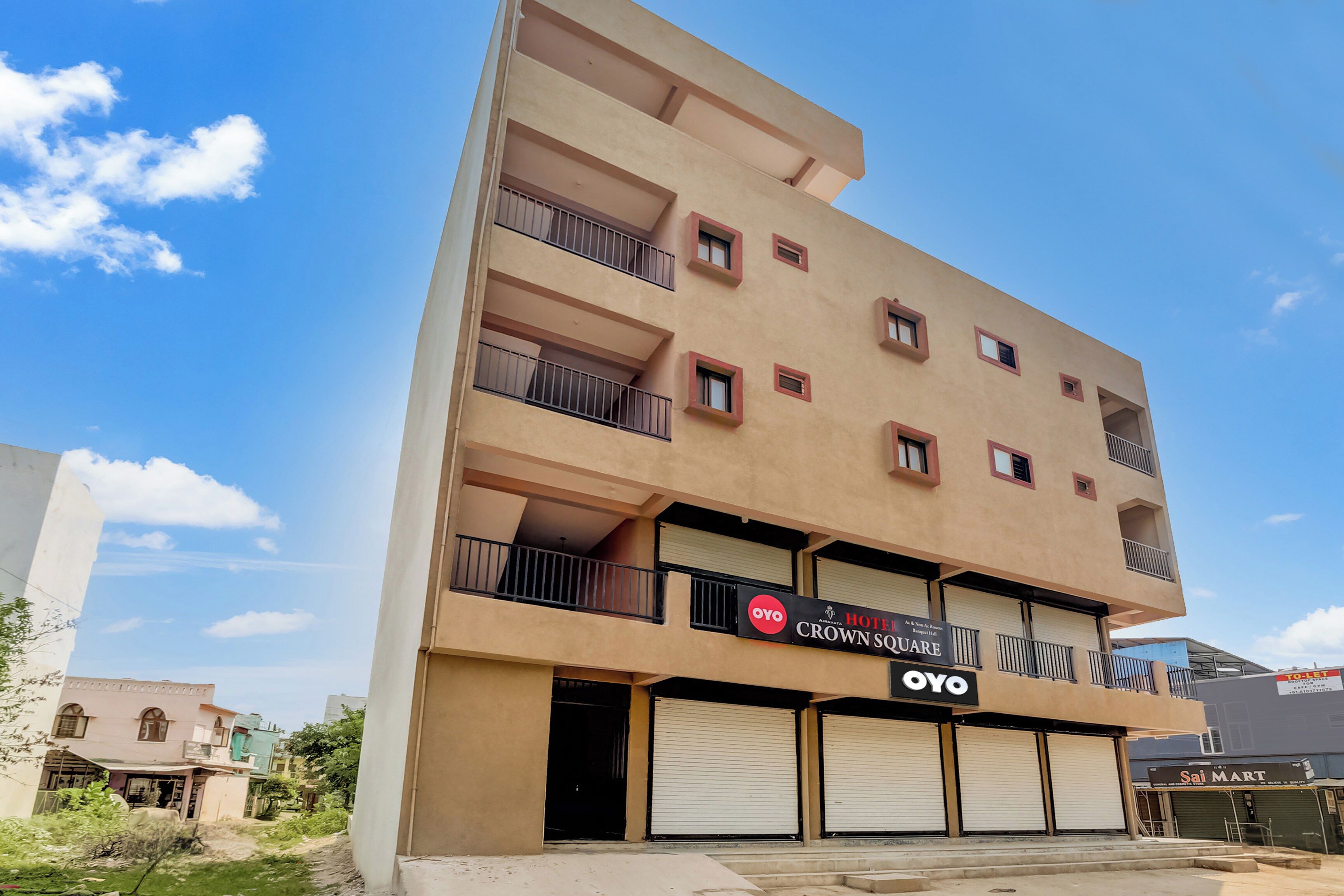 A multi-story hotel with a flat facade, balconies, and a sign for OYO Crown Square.
