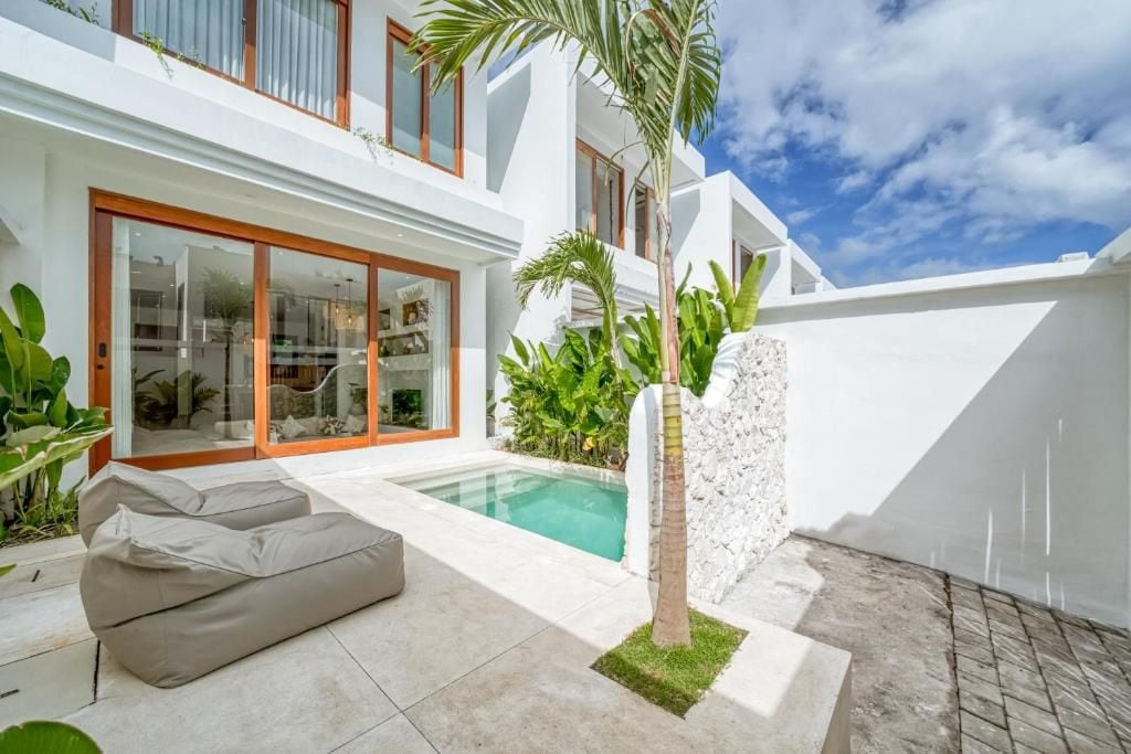 A modern house with a swimming pool, a covered patio, and a small garden.