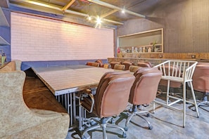 A conference room with a long table, leather chairs, and a high ceiling with exposed beams. - Palette Hotel by CheckIn Zero Mile (Nagpur)