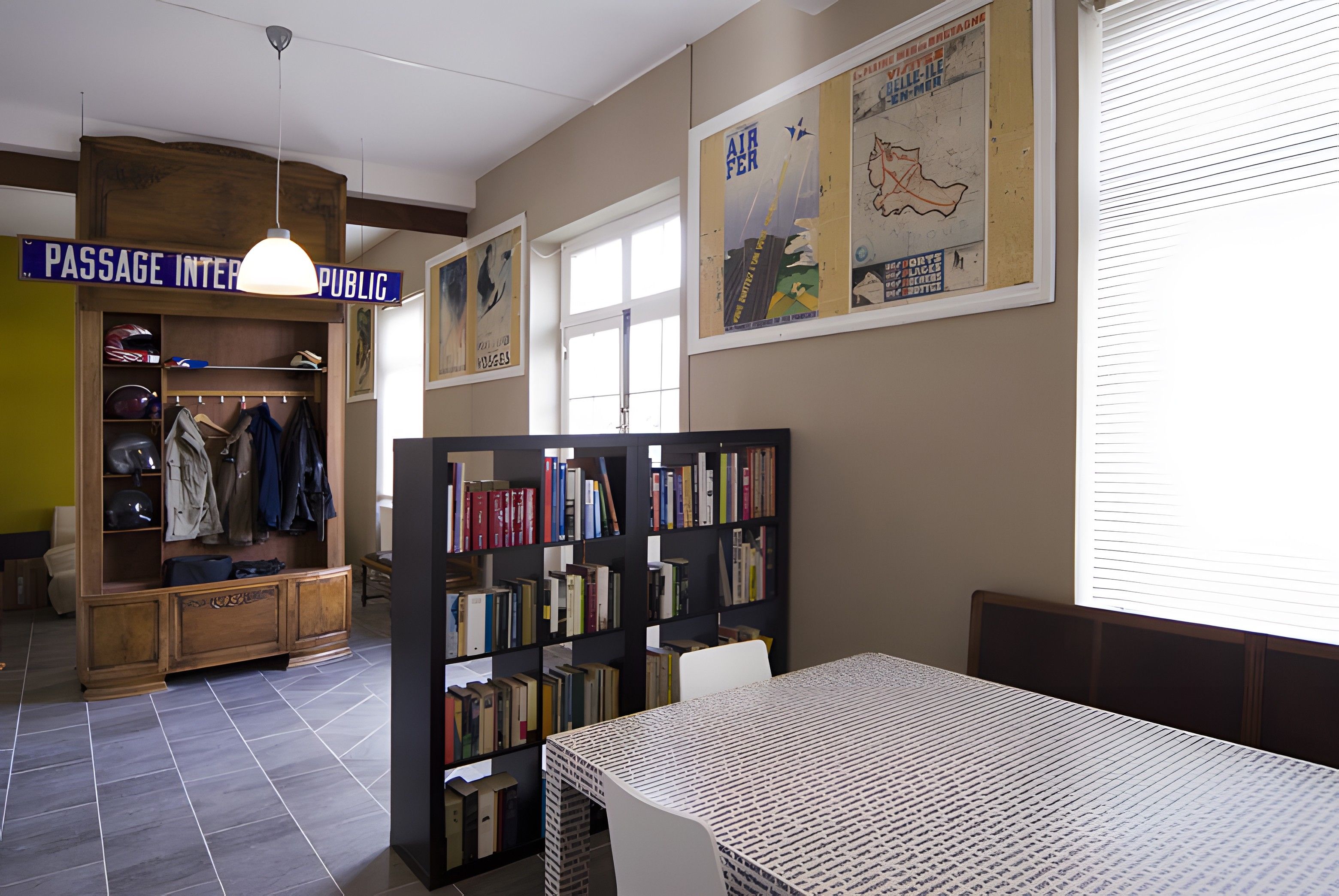 Una biblioteca con estanterías, una mesa y un pasillo identificado como 'PASSAGE INTERPUBLIC'.