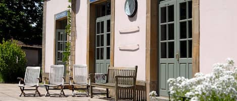 A building with a clock, a sign for 'BAGAGES', and outdoor seating.