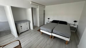 Une chambre à coucher comprenant un lit, une table de chevet, une commode et une chaise.