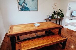 A wooden bench with a white bowl on top, a painting on the wall, and a plant on a side table. - The Perfect Family & Furry-Friend Getaway in Heart of Charlestown (Charlestown)