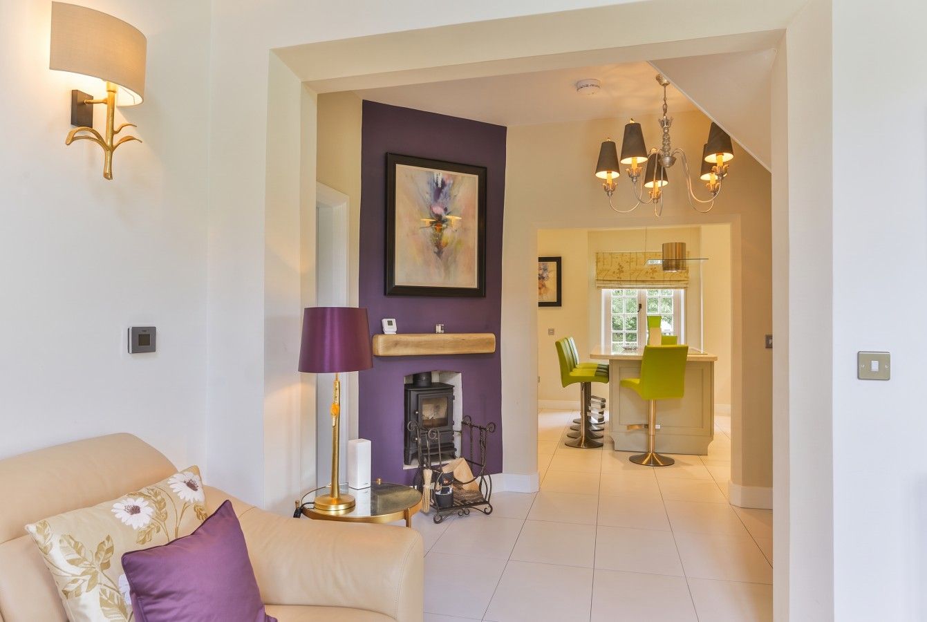 Living room opens through to the kitchen past the display wood burner.