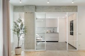 A modern kitchen with white cabinets, a black faucet, and a potted plant. - New Listing (Madrid)