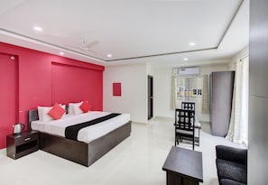A modern hotel room with a large bed, a desk, and a chair. - Super Hotel O by OYO 75327 Atithi (Bangalore)