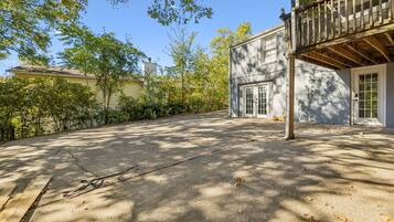 A residential property with a paved driveway, a wooden deck, and a garage door.