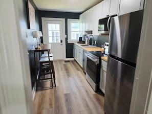 Una cocina con refrigerador, horno y ventana.
