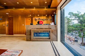 A hotel reception area with a wooden interior, a reception desk, and a view of the street outside. - Hotel O Briklane (Bengaluru)