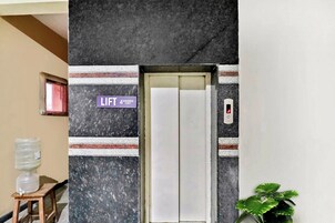 Elevador com placa indicando que só pode ser usado por até quatro pessoas.
