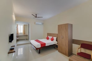 A hotel room with a bed, wardrobe, and a television. - Hotel O NCR Rooms (Bangalore)