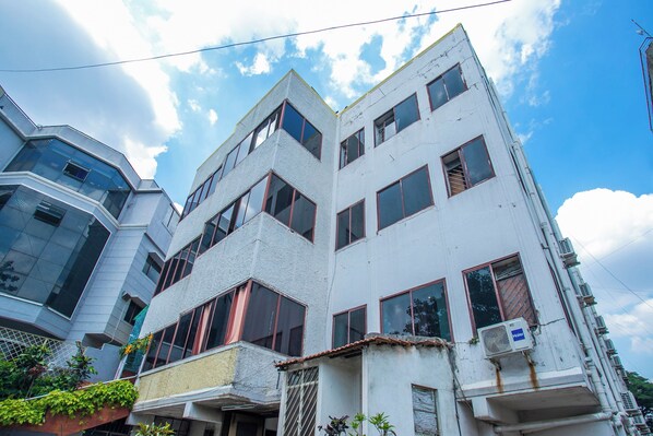 Un edificio de varios pisos con un diseño arquitectónico moderno, que presenta grandes ventanales y un techo plano.