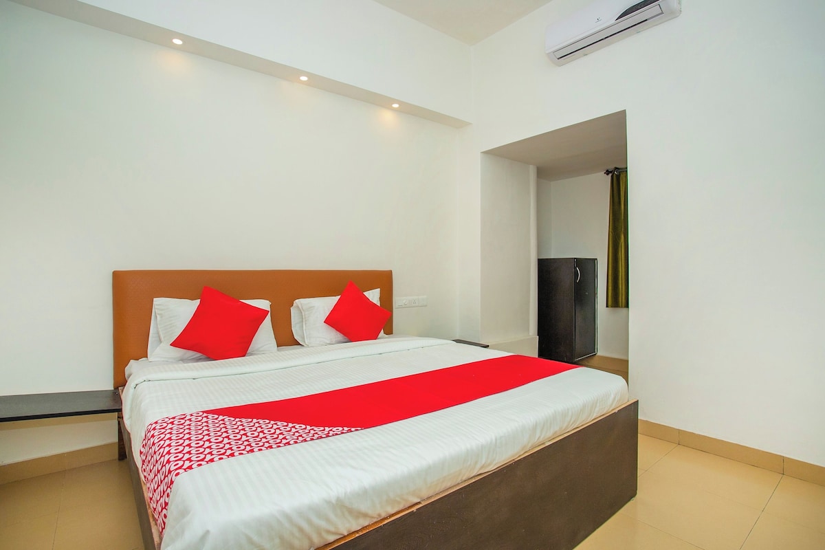 Una habitación de hotel con una cama grande, un armario y un equipo de aire acondicionado.