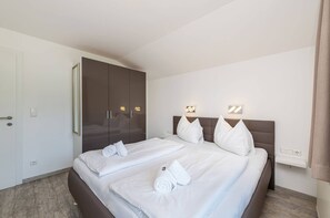 Une chambre d’hôtel avec un lit, une armoire et une table de chevet.