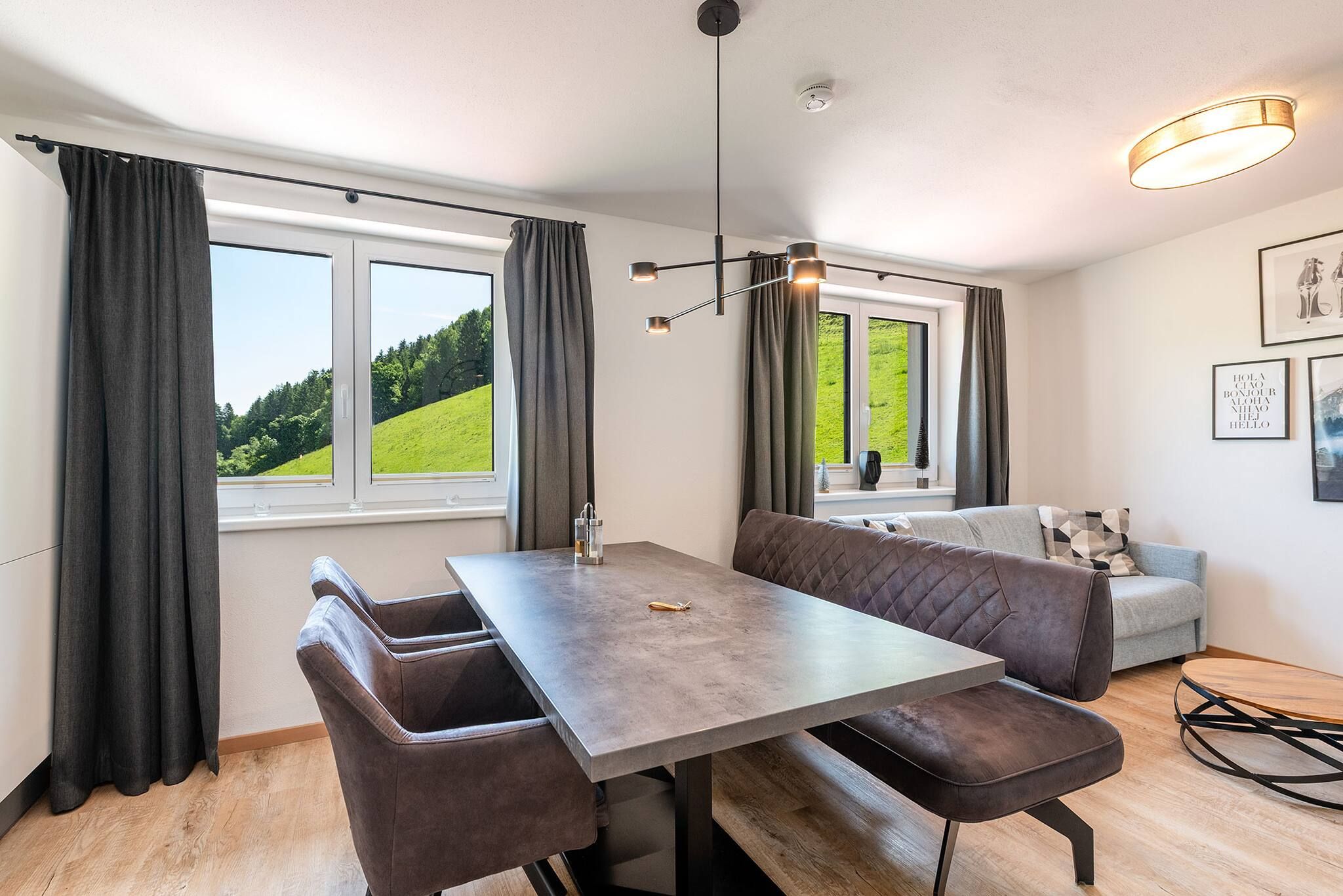 Ein moderner Essbereich mit einer Bank, Stühlen und einer Couch.