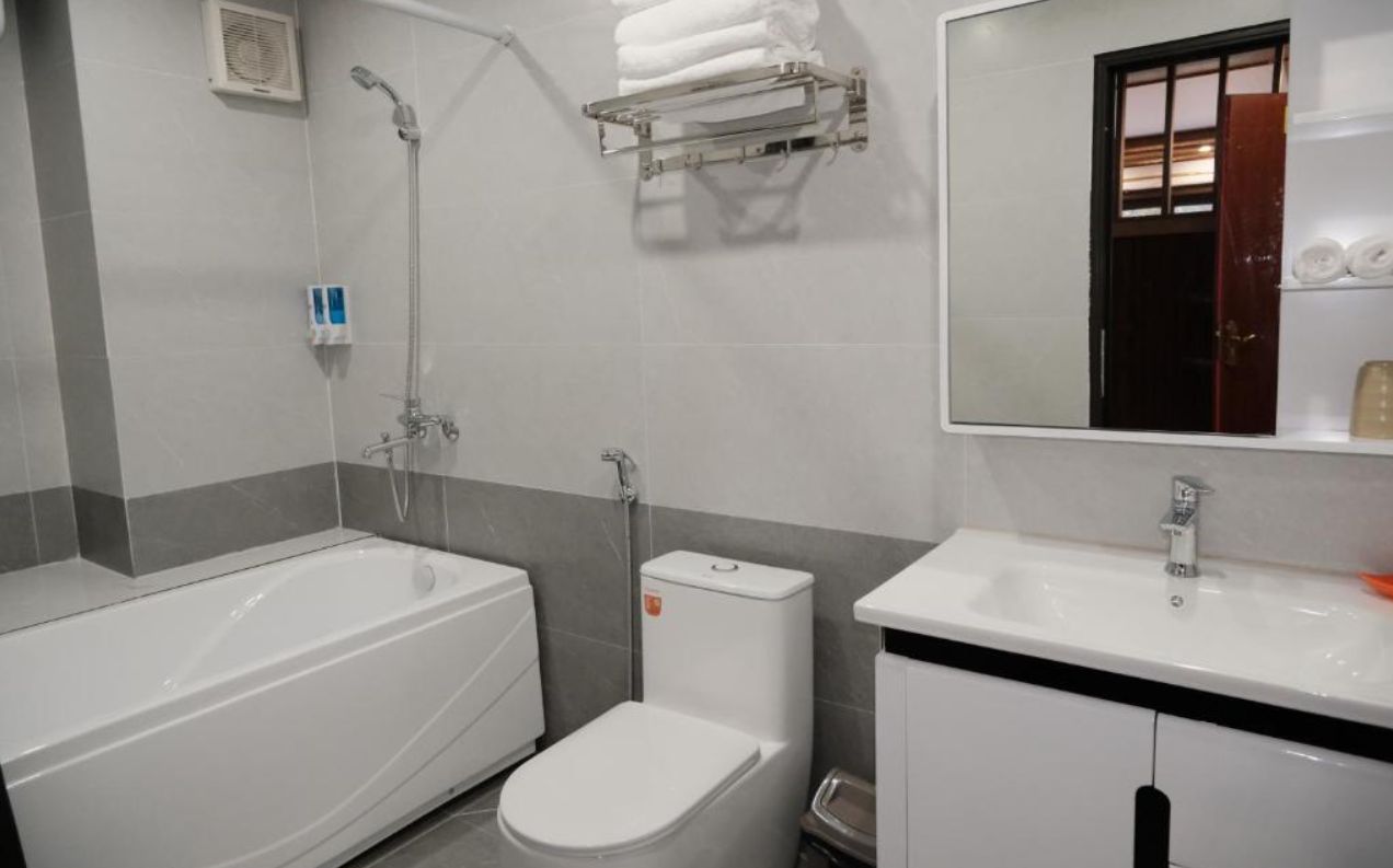 Un baño con bañera, inodoro, lavabo y espejo.