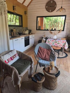Una habitación acogedora con kitchenette, zona de comedor y ventana con vistas a zonas verdes.
