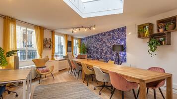 A modern kitchen with a skylight, wooden table, and chairs.