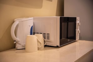 Un microondas y una cafetera sobre una encimera.