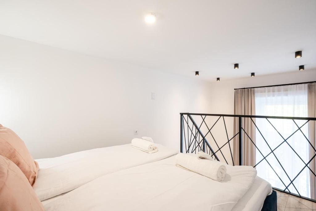 Ein Hotelzimmer mit zwei Betten, einem Fenster mit Vorhängen und einer Deckenlampe.