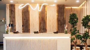 Un mostrador de recepción de diseño moderno, con paneles de madera verticales y una encimera de mármol.