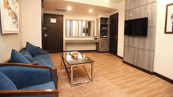 Uma sala de estar moderna com sofá, mesa de centro e televisão de tela plana na parede.