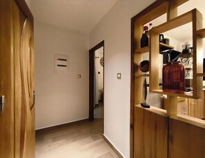 A hallway with wooden doors and a mirrored cabinet with various items. - New Listing (Yaoundé)