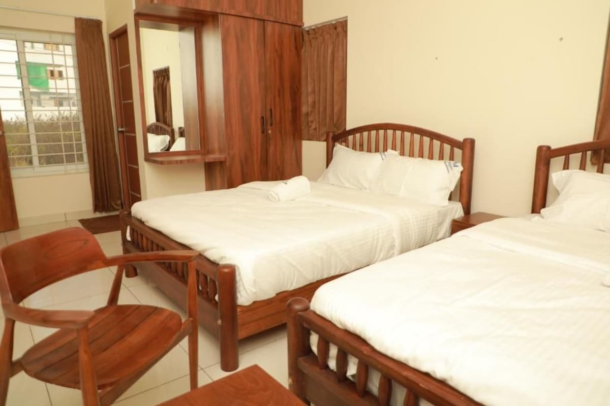 Un dormitorio con dos camas de madera, un armario de madera y una silla.