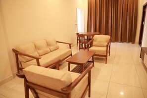 Una sala de estar con un conjunto de sofá, una mesa de centro y una mesa de comedor con sillas.