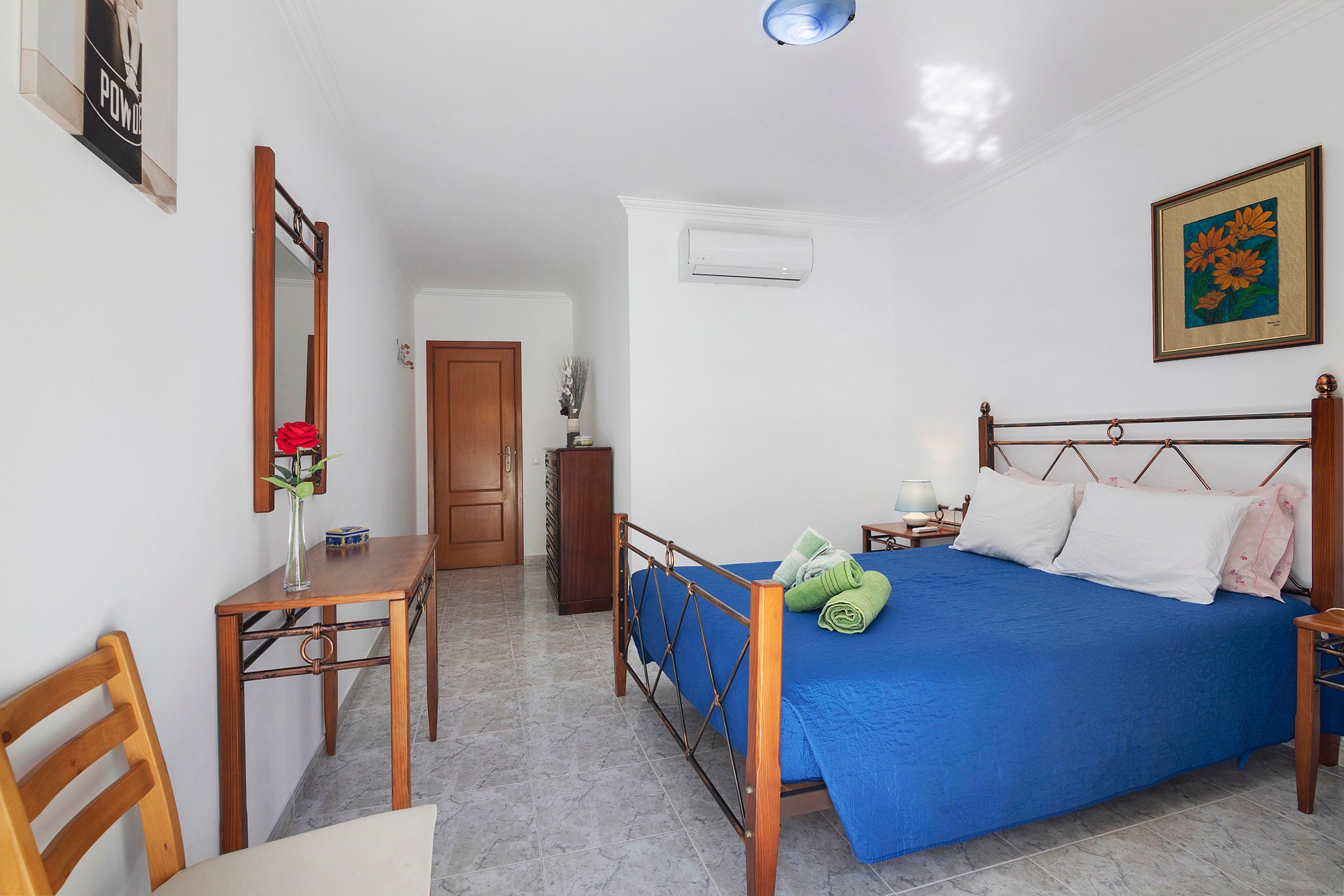 Une chambre à coucher avec un lit, un bureau, une chaise, une armoire et une porte.