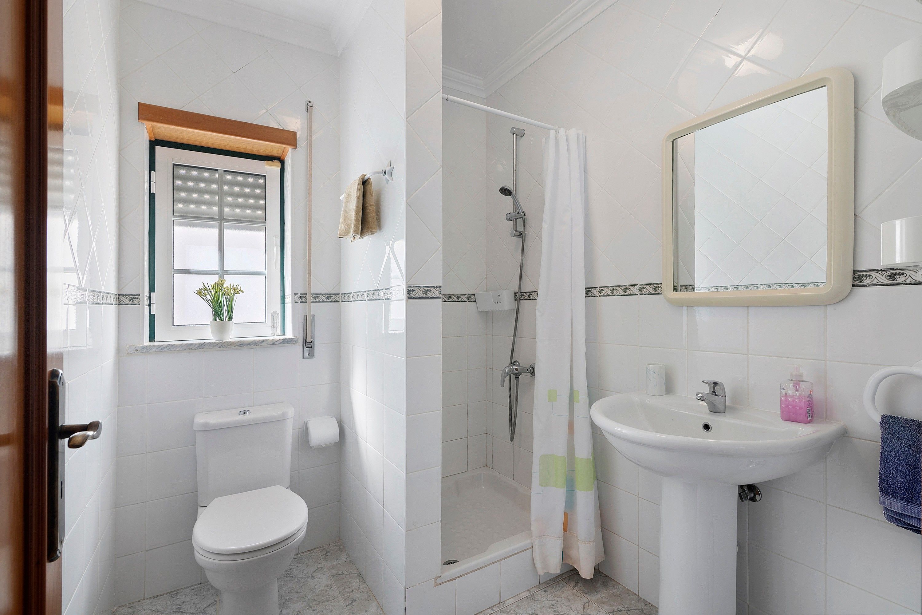 Ein Badezimmer mit Toilette, Dusche, Waschbecken und Spiegel.