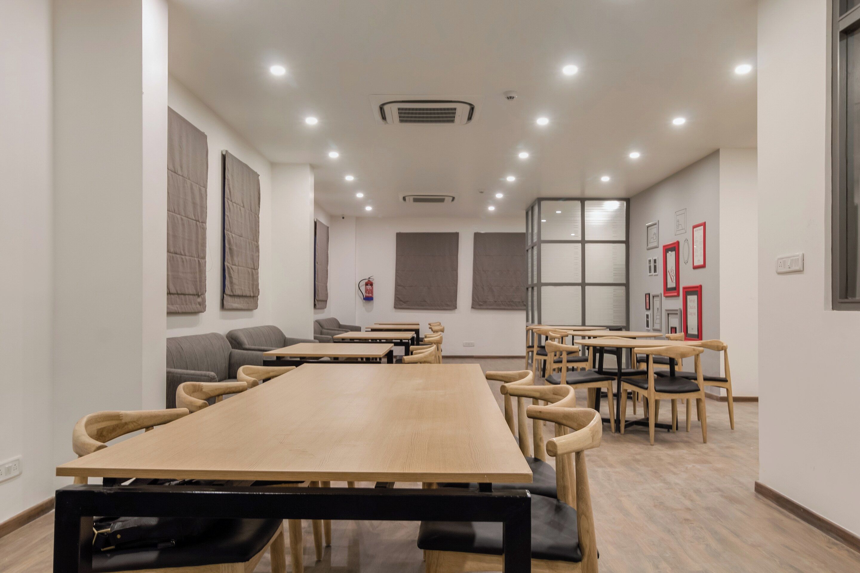 A conference room with a long table and chairs, white walls, and ceiling lights.