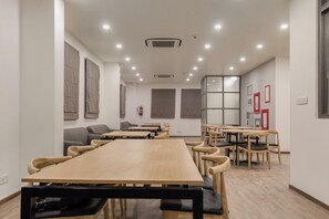 A conference room with a long table and chairs, white walls, and ceiling lights. - Hotel O Rammurthinagar (Bangalore)