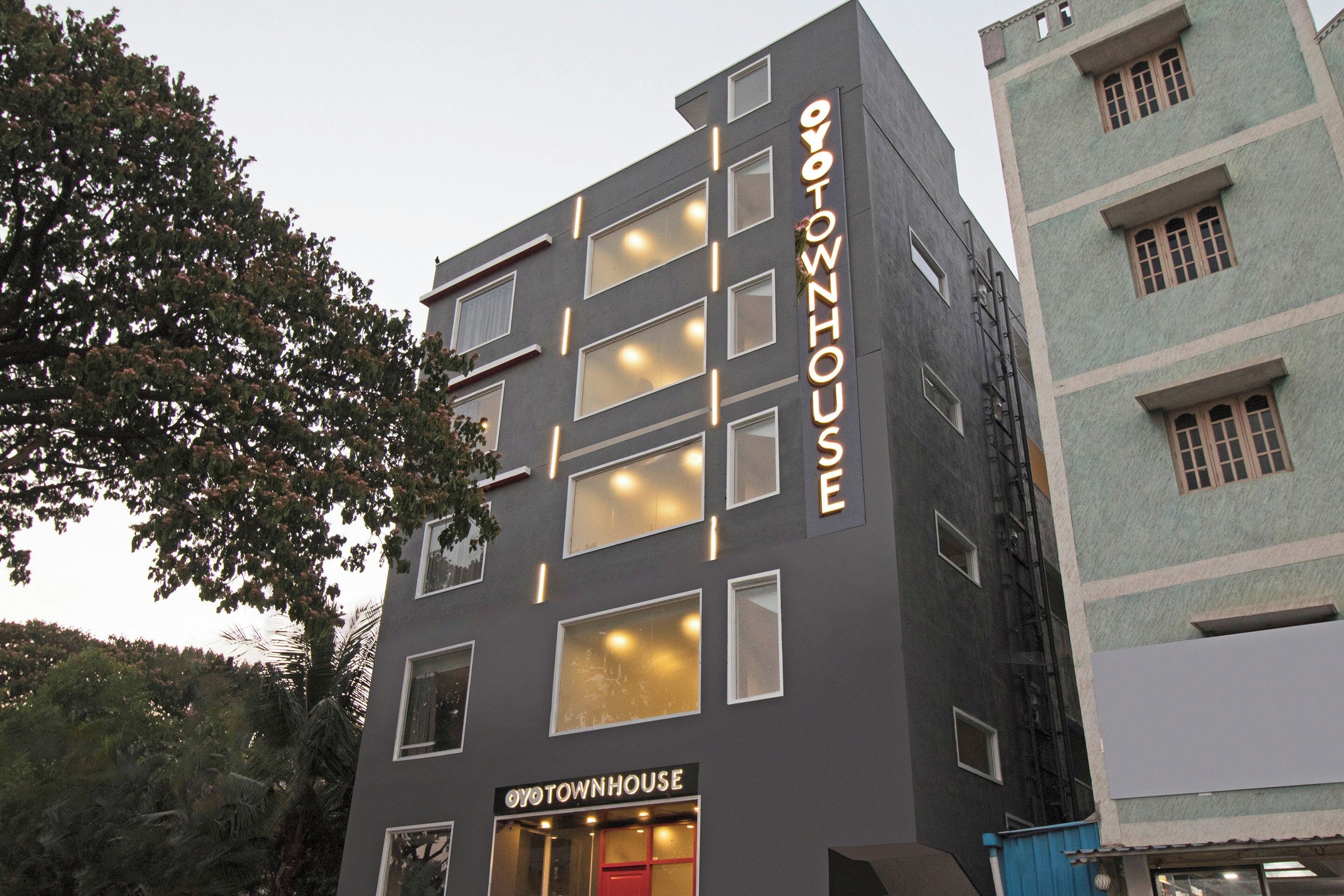 A multi-story building with a sign reading 'OYOTOWNHOUSE'.