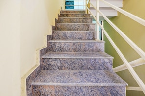 A staircase with granite steps and white railings. - Hotel O Together (Bangalore)
