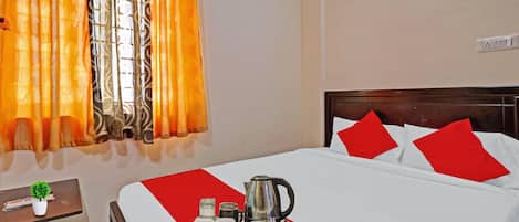 Une chambre d’hôtel avec un lit, une table de chevet, une fenêtre avec des rideaux et un plateau avec une bouilloire et des tasses.